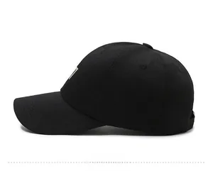 Detailed side view of black cotton baseball cap with white embroidery and air vents