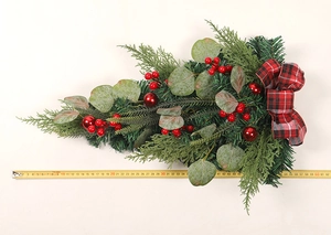 Detail of Christmas teardrop swag with eucalyptus leaves, red berries, and plaid bow