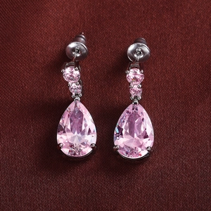 Elegant pink teardrop zircon earrings with pear-cut stone on red textured fabric
