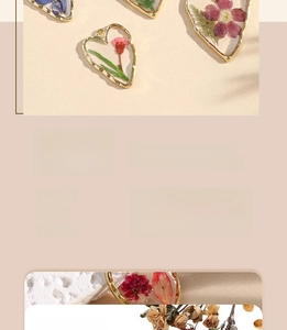 Detailed view of heart-shaped resin charms with real dried daisy flowers and gold metal frame
