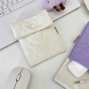 Close-up of quilted heart mini storage pouch with snap button for digital accessories