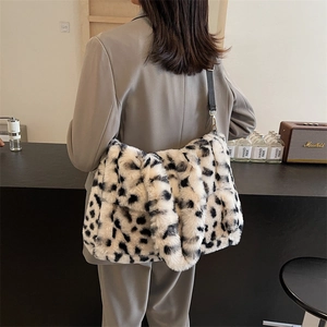 Fashionable leopard print plush tote bag with black shoulder strap worn by a model