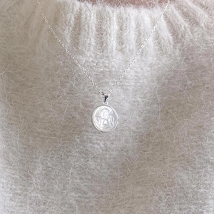 Minimalist 925 sterling silver angel cherub relief necklace on white mohair sweater