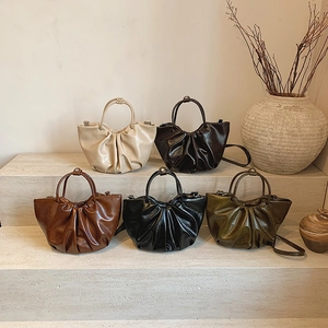 French pleated cloud tote bags in various neutral colors on elegant stone stairs