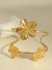 Detail of 18k gold plated flower shaped bracelet with polished metallic finish