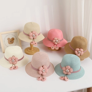 Detail of multi-color kids straw hats with floral ribbons on wooden display stands