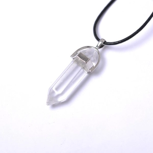 Detail of transparent hexagonal crystal point pendant with polished silver metal bail