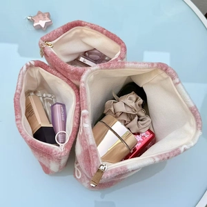 Pink checkered plush toiletry bag interior showing large storage capacity for cosmetics