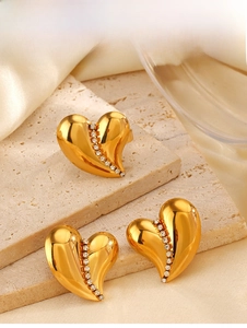 Macro view of 18K gold-plated heart jewelry set with vertical crystals on silk background