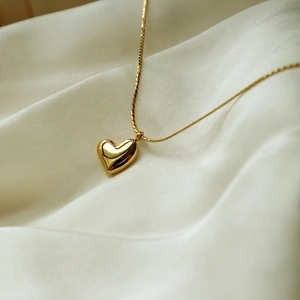 Elegante collana con ciondolo a cuore in oro su seta morbida con finitura lucida