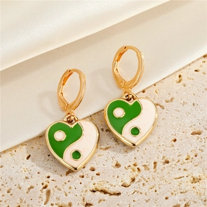 Detailed shot of gold heart hoop earrings with green and white yin yang enamel accents