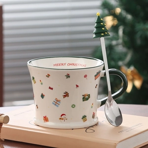 Macro detail of Christmas ceramic mug with green handle and tree-topped metal spoon