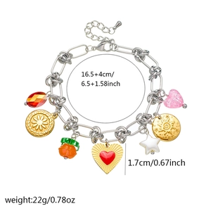 Silver chain bracelet featuring charms like a red heart, pink crystal, and gold coin