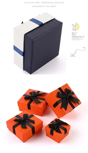 Detail of square jewelry gift boxes in blue and orange with ribbon bow accents