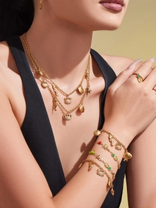 Détail de colliers dorés à plusieurs rangs avec pendentifs marins sur le mannequin