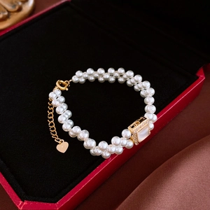 Détail d'un bracelet de perles à double rangée avec breloque cœur S925 et gemme