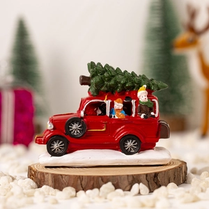 Christmas red resin truck figurine with green pine tree and colorful figurines on snow