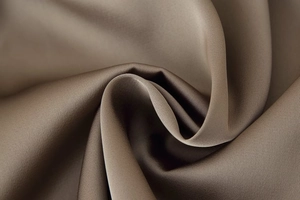 Macro detail of the bronze satin fabric texture and glossy sheen of the wide-leg trousers