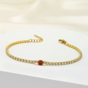 Gold stainless steel tennis bracelet featuring clear zircons and a central red gemstone