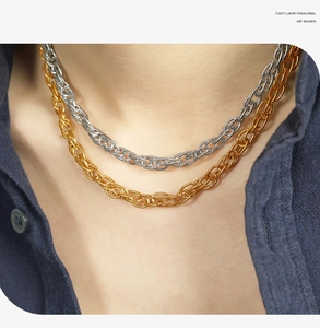Detail of woven chain necklaces in gold and silver finish worn by a model