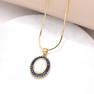 Detalle de la cadena de serpiente dorada con colgante de María y circonitas azules