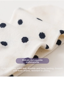 Close-up of white knitted cotton socks with navy blue polka dots and fine stitching