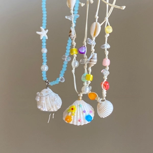 Close-up of wax rope necklace featuring natural shells, sea stars and blue beads