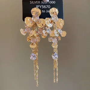 Golden flower earrings with purple crystal center and long tassel pendants on 925 silver studs