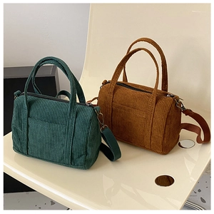 Detail of retro corduroy Boston bags in dark green and caramel with textured fabric