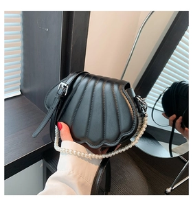 Detailsicht der schwarzen Muscheltasche mit Perlengriff und vertikaler Textur aus PU-Leder