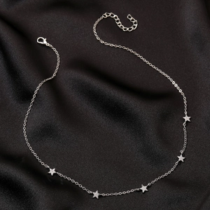 Dettaglio della collana d'argento con stelle e zirconi lucidi su raso nero elegante