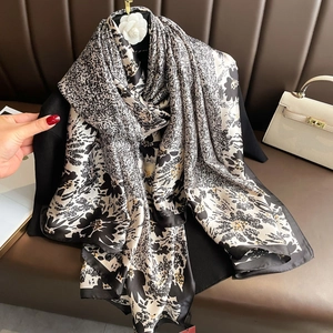 Elegant large black and white floral print silk scarf with camellia accessory on a bag