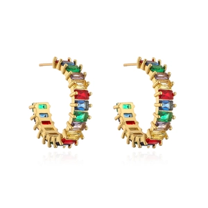 Detailed macro shot of C-shaped gold earrings with colorful rectangular zirconia stones