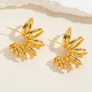 Macro shot of gold-plated U-shaped earrings with hammered texture and round zircon