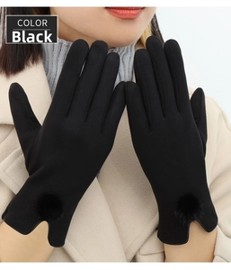 Close-up of black thermal winter gloves for women with decorative plush ball and V-shaped cuff