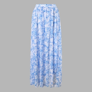 Detail of white maxi skirt featuring blue palm leaf print and flowing A-line silhouette