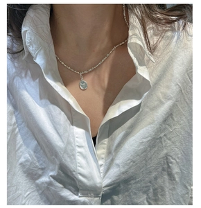 Close-up of S925 silver necklace with Smile engraved oval pendant on a model