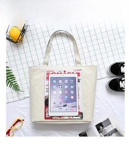 Large beige canvas tote bag showing interior capacity with iPad and magazine