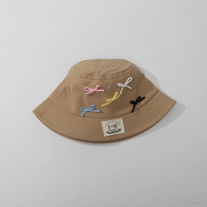 Detail of khaki cotton sun hat with colorful bow accents and FIERCECAT woven label