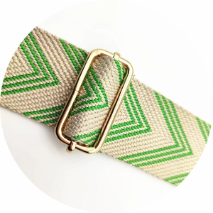Detailed close-up of thickened beige and green herringbone woven bag strap with gold buckle