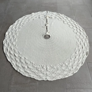 Detail view of white cable knit Christmas tree skirt with decorative lace edge and tie closures