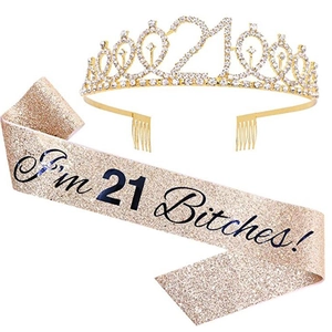 Detail of gold rhinestone tiara and 21st birthday sash with glitter fabric texture