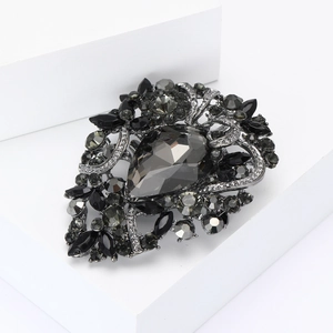 Macro view of vintage smoky gray crystal brooch with water drop gemstone and rhinestones