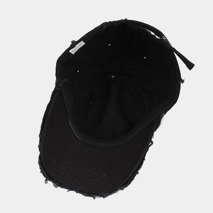Internal view of black distressed cotton baseball cap showing 100% cotton label and lining
