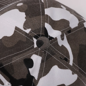 Close-up of camouflage baseball cap top showing cotton twill texture and stitching