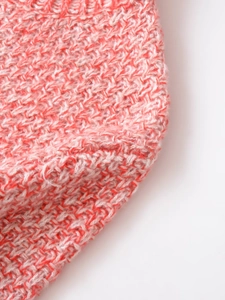 Macro view of marl knit fabric texture in red and white blend for long sleeve sweater