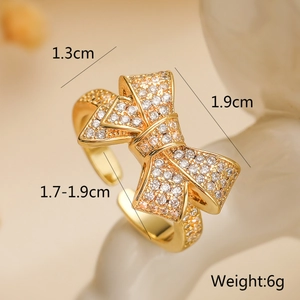 Detailed macro view of 18K gold bow ring featuring sparkling white cubic zirconia stones