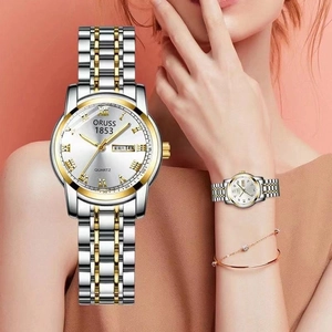 Close-up of silver steel quartz watch with dual calendar display and gold accents