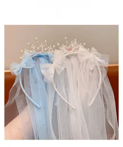 Detail of girl's princess crown headband with layered tulle veil and pearl bow accents