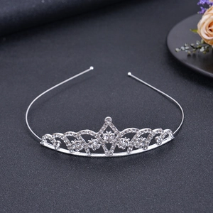 Nahaufnahme einer versilberten Tiara für Mädchen mit filigranem Bogenmuster und Kristallbesatz